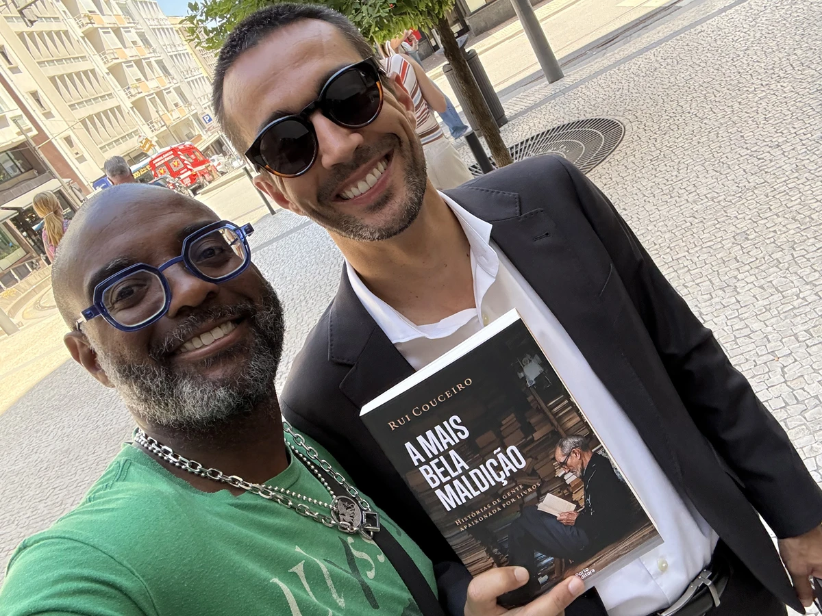 Two men, one holding a book