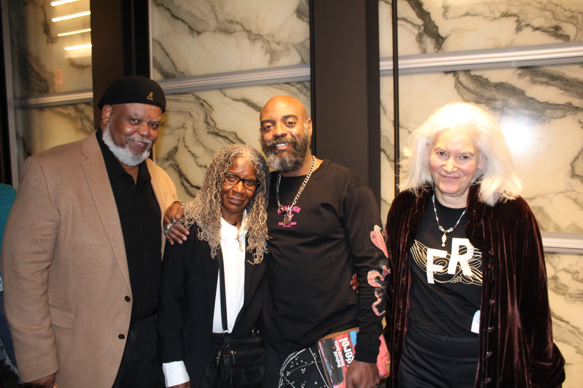 Freedom Reads Founder & CEO Reginald Dwayne Betts stands with three people, family and friends, smiling after his March Forth performance at the Perelman Performing Arts Center in New York City this month.
